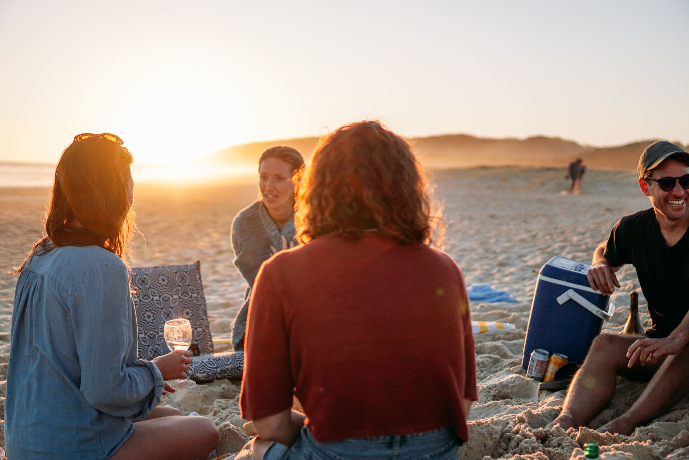A South African beach gathering at sunset, the kind of outing a Fieldbar cooler box is packed for